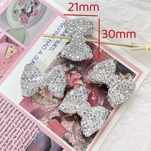 Detailed view of silver bow-shaped rhinestone charms in 21mm and 30mm sizes for DIY jewelry