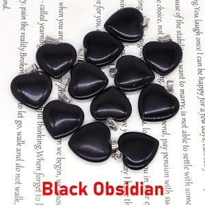 Pendentifs en obsidienne noire en forme de cœur avec fermoirs en métal sur fond blanc