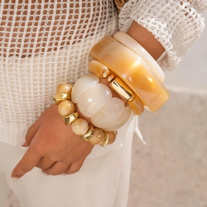 Detail of Bohemian resin bangle set in amber and cream with metallic gold accents