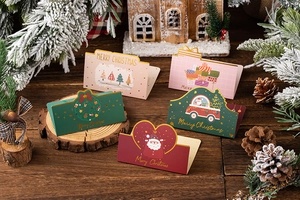 Close-up of 3D folding Christmas gift cards with festive tree and Santa motifs