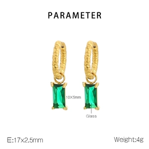 Détail de boucles d'oreilles dorées avec anneaux martelés et pendentifs en verre vert