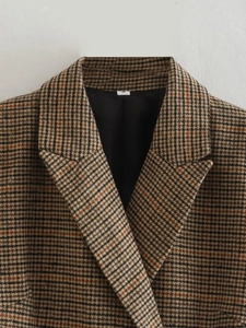 Détail du col d'un blazer à carreaux marron et revers montrant la texture de la laine