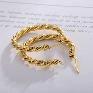 Minimalist twisted gold hoop earrings with textured rope design and polished finish