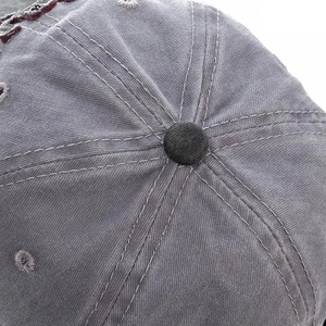 Macro shot of retro washed cotton baseball cap top with six-panel stitching and metal button