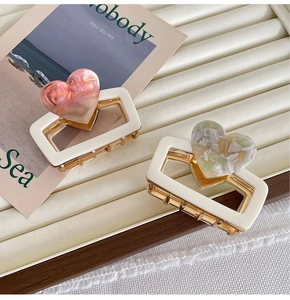 Detail of 6cm golden heart hair claws with pink pearl and green marble resin accents