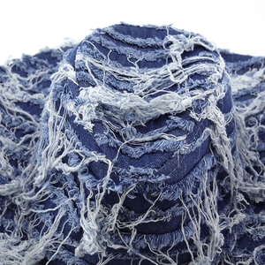 Detail of distressed indigo denim bucket hat with frayed edges and raw fringe textures