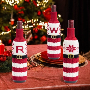 Detalle macro de fundas de punto para botellas de Navidad con letras R, W y copos