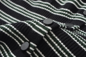 Detailed close-up of high-quality striped knit fabric and matte round button textures