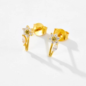 Macro detail of gold flower earrings with white zircons and S925 silver stamp