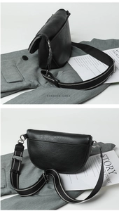 Detail view of black textured saddle bag with silver hardware and woven strap