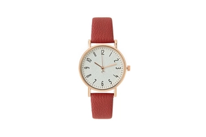 Detail of red leather strap and rose gold case on a minimalist women's quartz watch