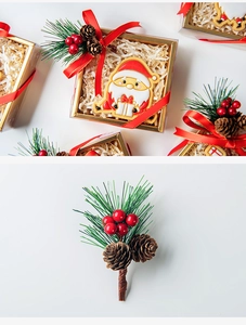 Macro shot of Christmas pine cone and red berry decorative accents on a gift box