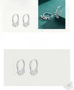 Detail of S925 sterling silver hoop earrings with five sparkling round stone pendants