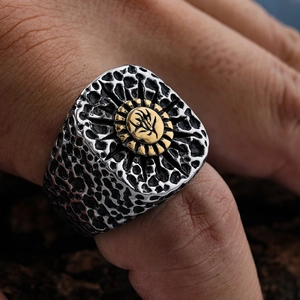 Detail of vintage punk skull ring with golden sun totem and distressed silver texture