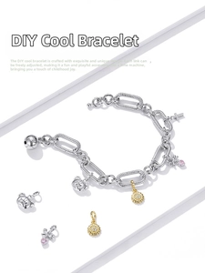 Macro shot of silver charm bracelet with pink heart bow and sunflower pendant charms