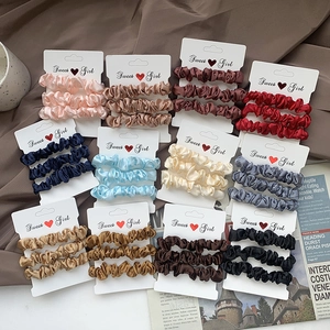 Set of 3 satin silk scrunchies in various colors on display cards for hair styling