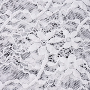 Macro view of white floral lace fabric with intricate embroidery and sheer texture