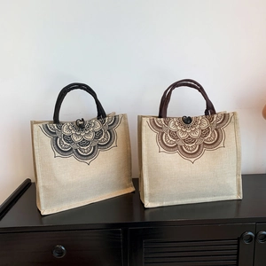 Ethnic style large linen tote bags with mandala print in beige color on a wooden stand