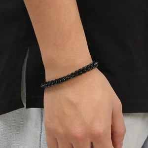 Close-up of black matte stainless steel Cuban link bracelet worn on a wrist