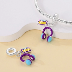 Detailed view of purple headphone and retro tape charms with colorful enamel finish