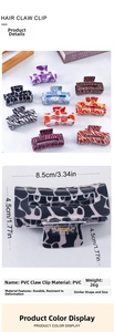 Detail view of PVC hair claw clip showing cow print pattern and 8.5cm x 4.5cm dimensions