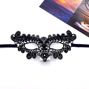 Detailed view of black lace eye mask with intricate floral embroidery and elastic band