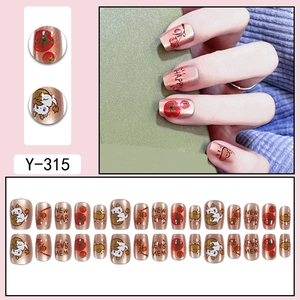 Detailed view of rose gold festive press-on nails with white cat and cherry patterns