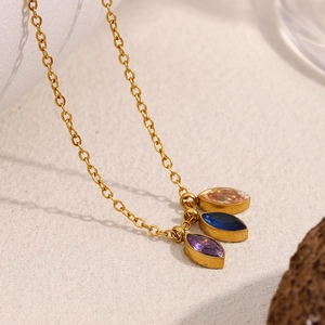 Macro shot of 18K gold plated necklace featuring purple, blue and champagne zircon eyes