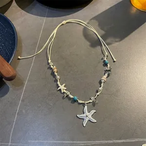 Close-up of ocean-themed handmade necklace with large white starfish and blue beads
