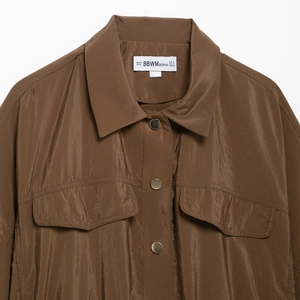 Chemise style safari marron avec texture soyeuse, col pointu et poches sur la poitrine