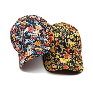 Détails de deux casquettes de baseball à fleurs bleu marine et jaunes à motifs denses