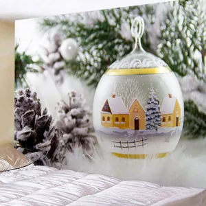 Détail d'une boule de Noël avec motif peint à la main d'un paysage de village enneigé