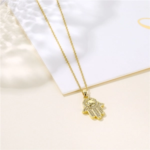 Collier avec pendentif Main de Fatma serti de zircons sur une chaîne à maillons dorés