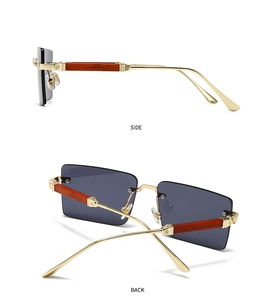 Detail einer randlosen rechteckigen Sonnenbrille mit Bügeln in Holzoptik und Goldgelenk