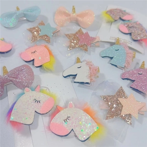 Close-up of glittery unicorn hair clips and star mesh hairpins in pastel colors