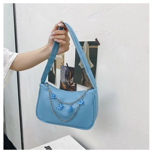Detail of blue PU leather underarm bag with silver chain and blue butterfly charms