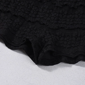 Nahaufnahme der schwarzen Spitzendetails mit floralem Muster auf den gestreiften Shorts