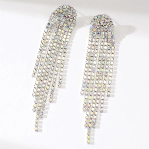 Macro detail of long silver fringe earrings with shimmering rainbow rhinestones on white background