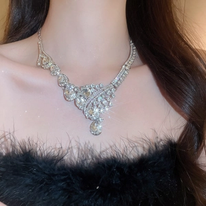 Luxurious silver water drop pendant necklace with shimmering crystals on a model wearing black