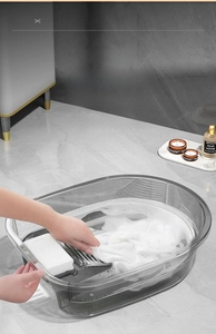 Détail d'une bassine à linge grise transparente avec planche à laver intégrée en PET durable