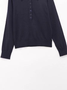 Dettaglio polo in maglia blu scuro con bordo a costine e trama del colletto a bottoni