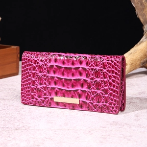 Close-up of rose red crocodile embossed leather wallet with elegant gold metal detail