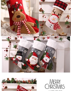 Details von gestrickten Weihnachtssocken mit Weihnachtsmann und Rentier am Kamin