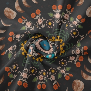 Detail of bohemian tapestry featuring moon phases, orange floral prints, and mandala motifs