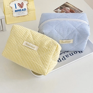 Pastel candy striped quilted makeup bags in yellow and blue colors with Purdored logo label