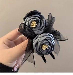 Detail of dark grey fabric flower hair claw clip with black lace mesh and beige center
