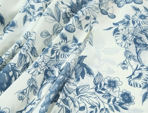 Detail of blue floral print on white fabric showing soft folds and fine texture