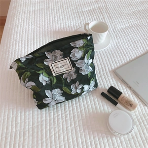 Close-up of vintage dark green floral embroidered canvas cosmetic bag with zipper