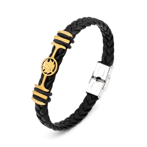 Detail of woven black leather bracelet with golden maple leaf and silver clasp