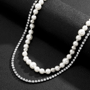 Detailed view of double layered necklace with white pearls and sparkling rhinestone chain
